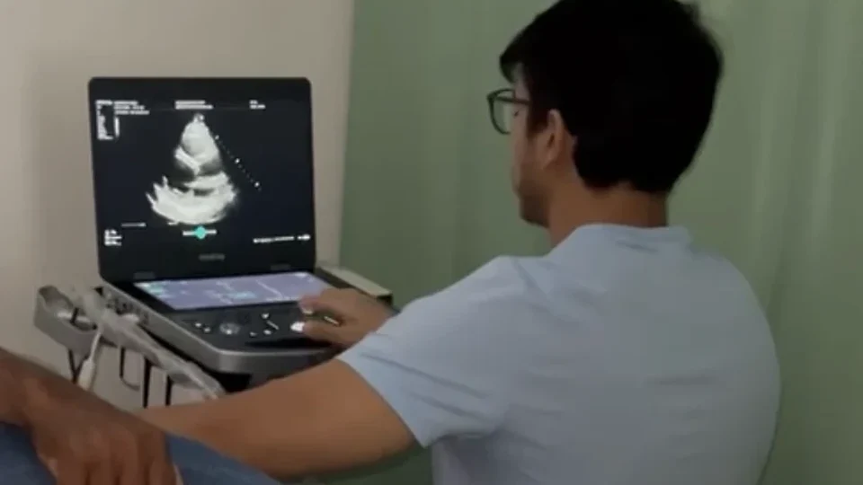 Profissional realizando ecocardiografia em ambiente clínico real.